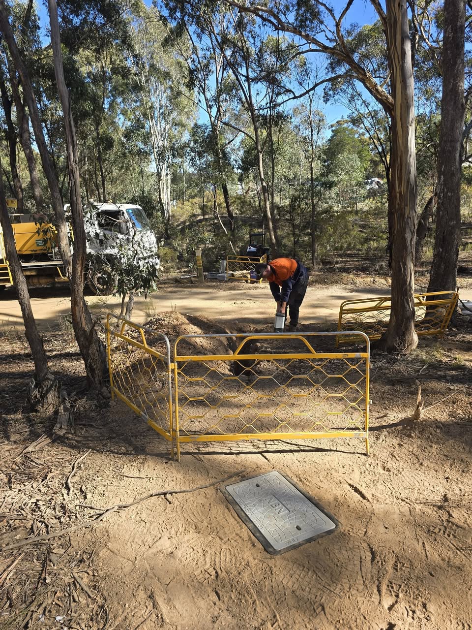 Out in the scrub — comms run through rocky ground, hard going but pushed through.